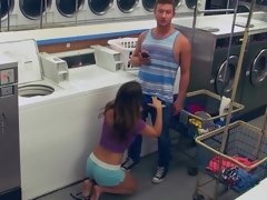 A couple is having fun in the laundromat while they are alone