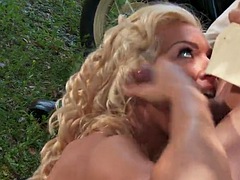 Stunning blonde babe takes care of his hard cock outdoors