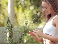 A bimbo that has natural tits is alone in the garden, naked